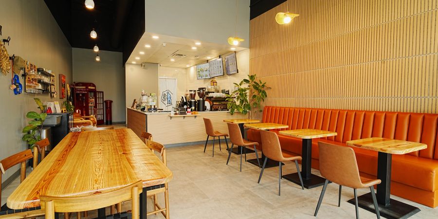 Modern cozy café interior with wooden tables and orange seating